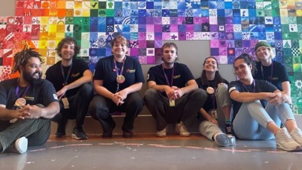 a Rainbow wall with all the QCH facilitators below it!
